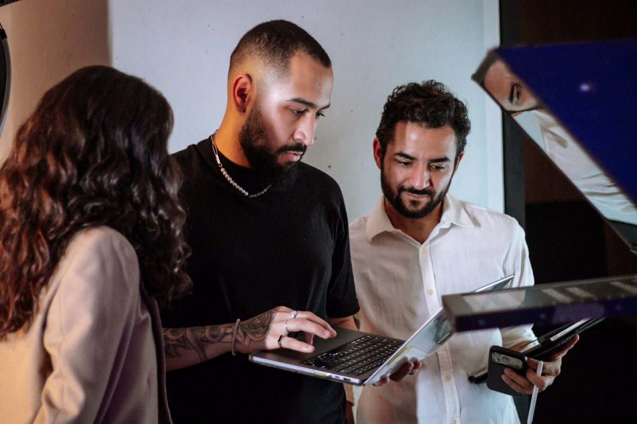 Lucas Has revisando um material com duas pessoas da equipe